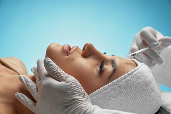 Mujer recibiendo tratamiento facial con inyecciones de Toxina Botulínica
