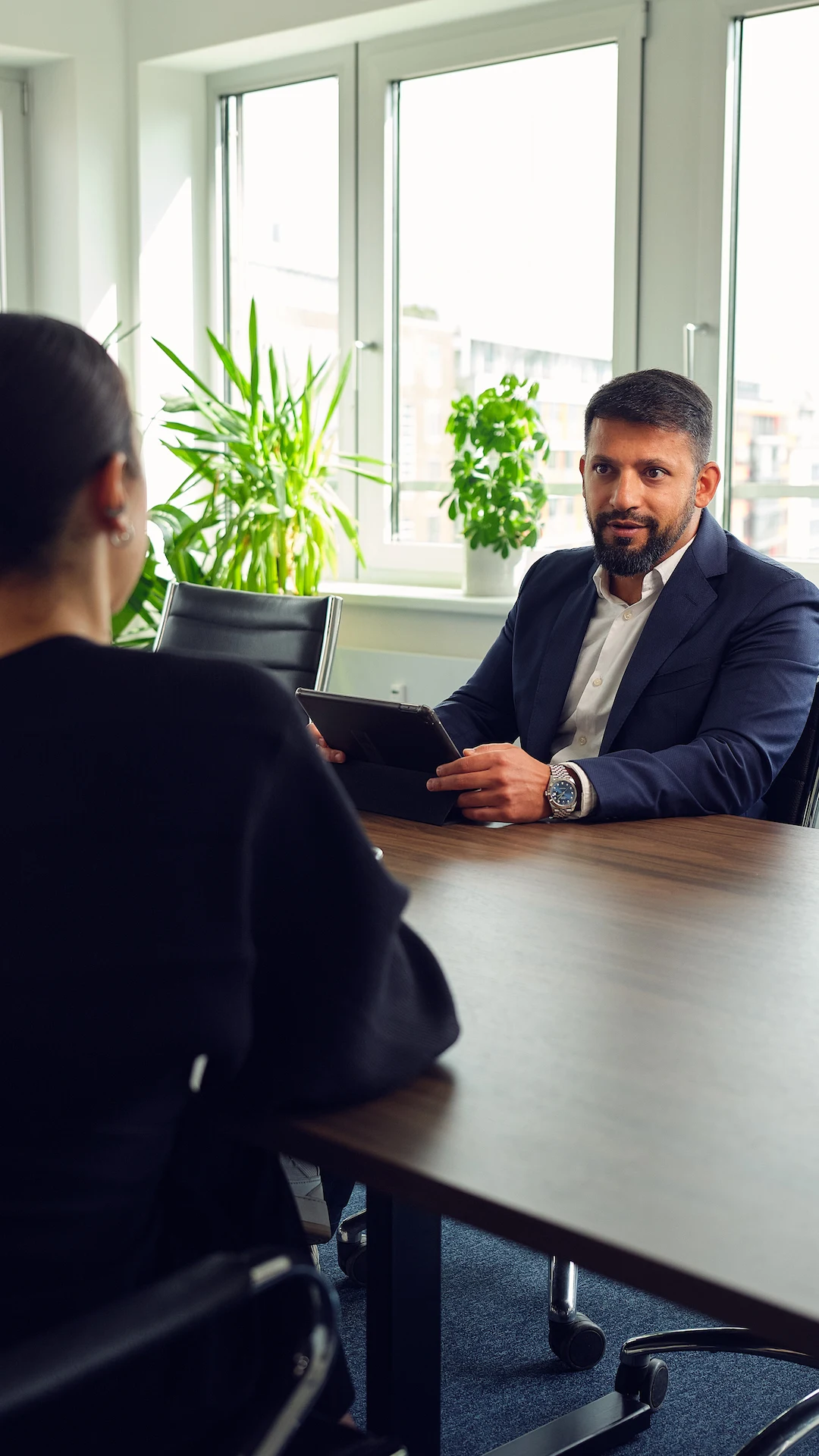 Mitarbeiter sitzen sich am Tisch gegenüber und führen ein Meeting