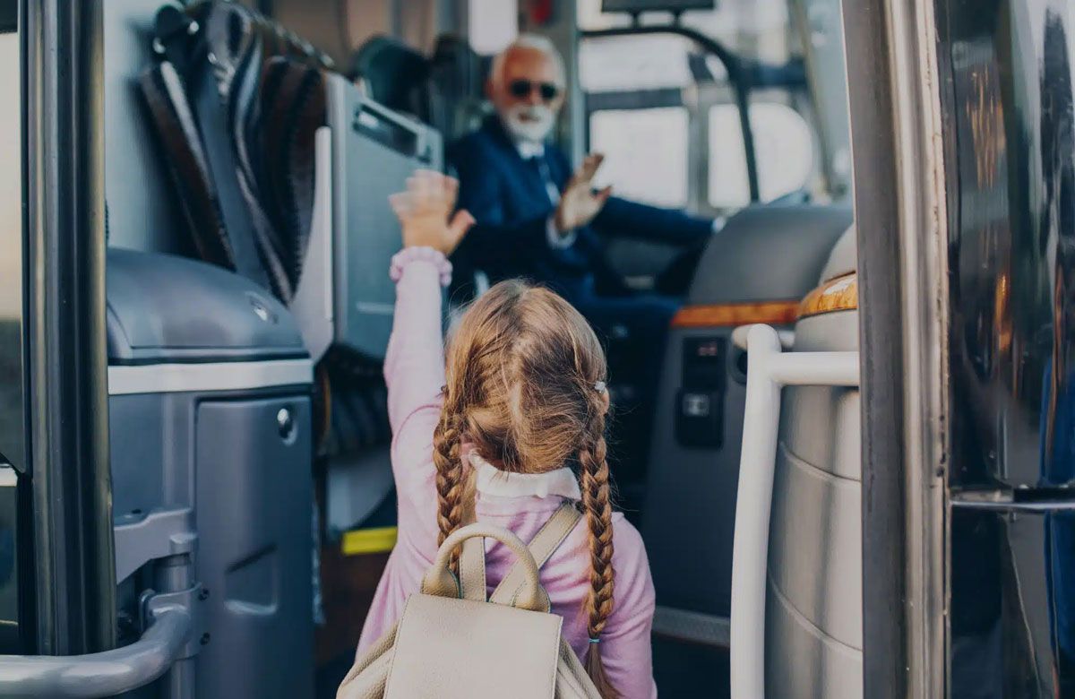 kind steigt in einen bus für klassenfahrt ein