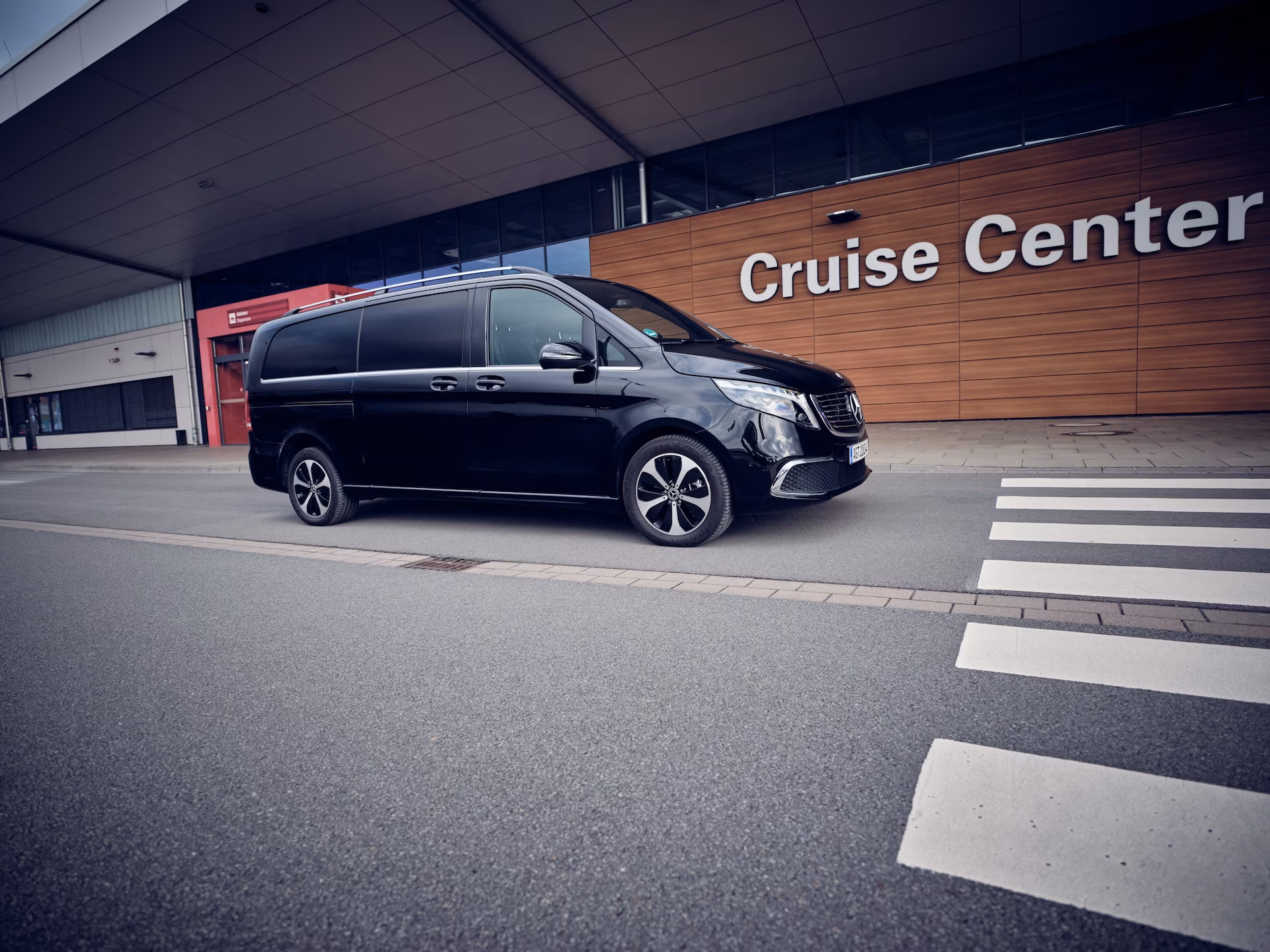 Schwarzer Shuttle-Van vor dem Cruise Center an einem Kreuzfahrtterminal.
