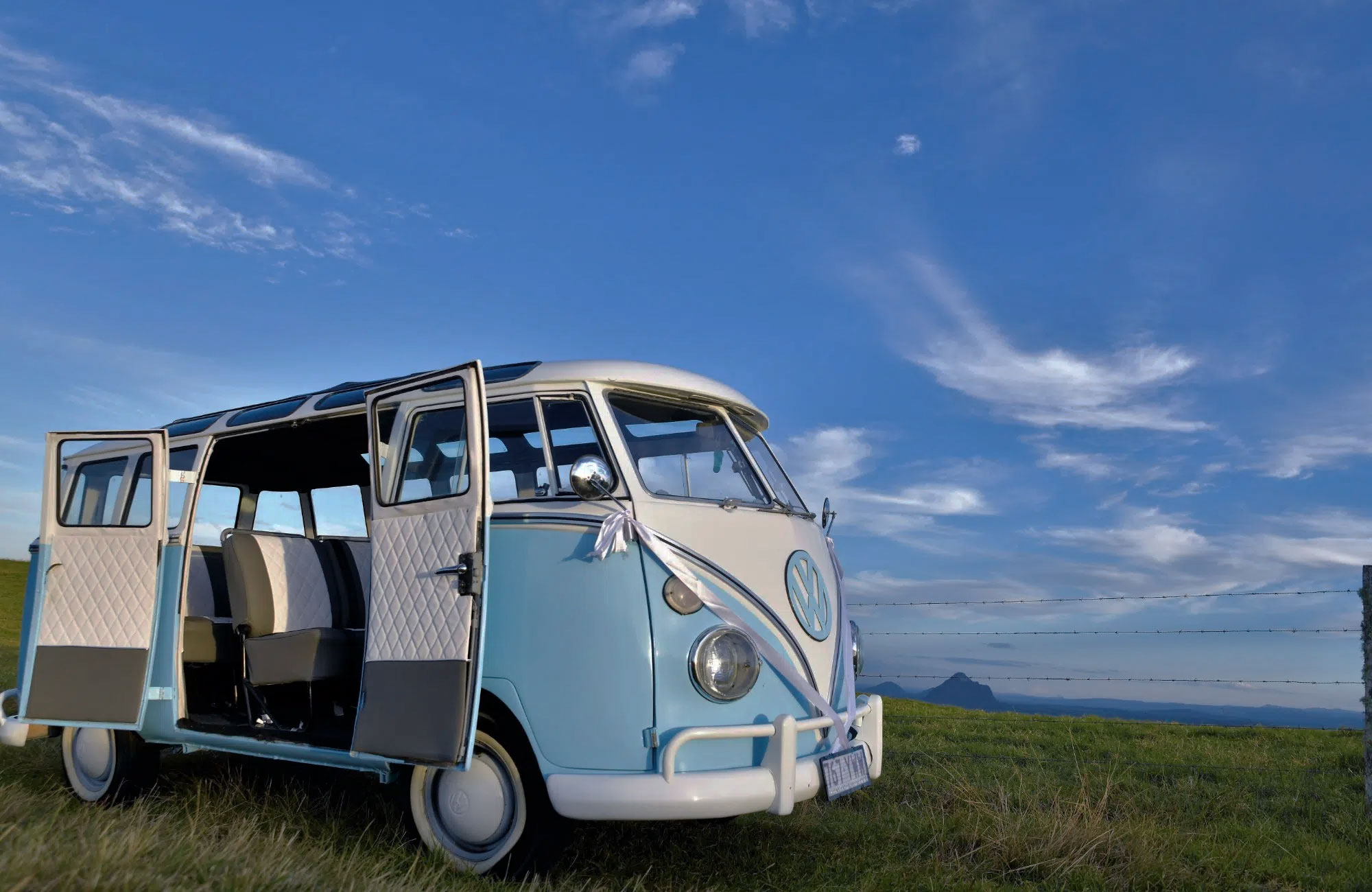 Hellblauer Oldtimerbus mit geöffneter Tür in Seitenansicht