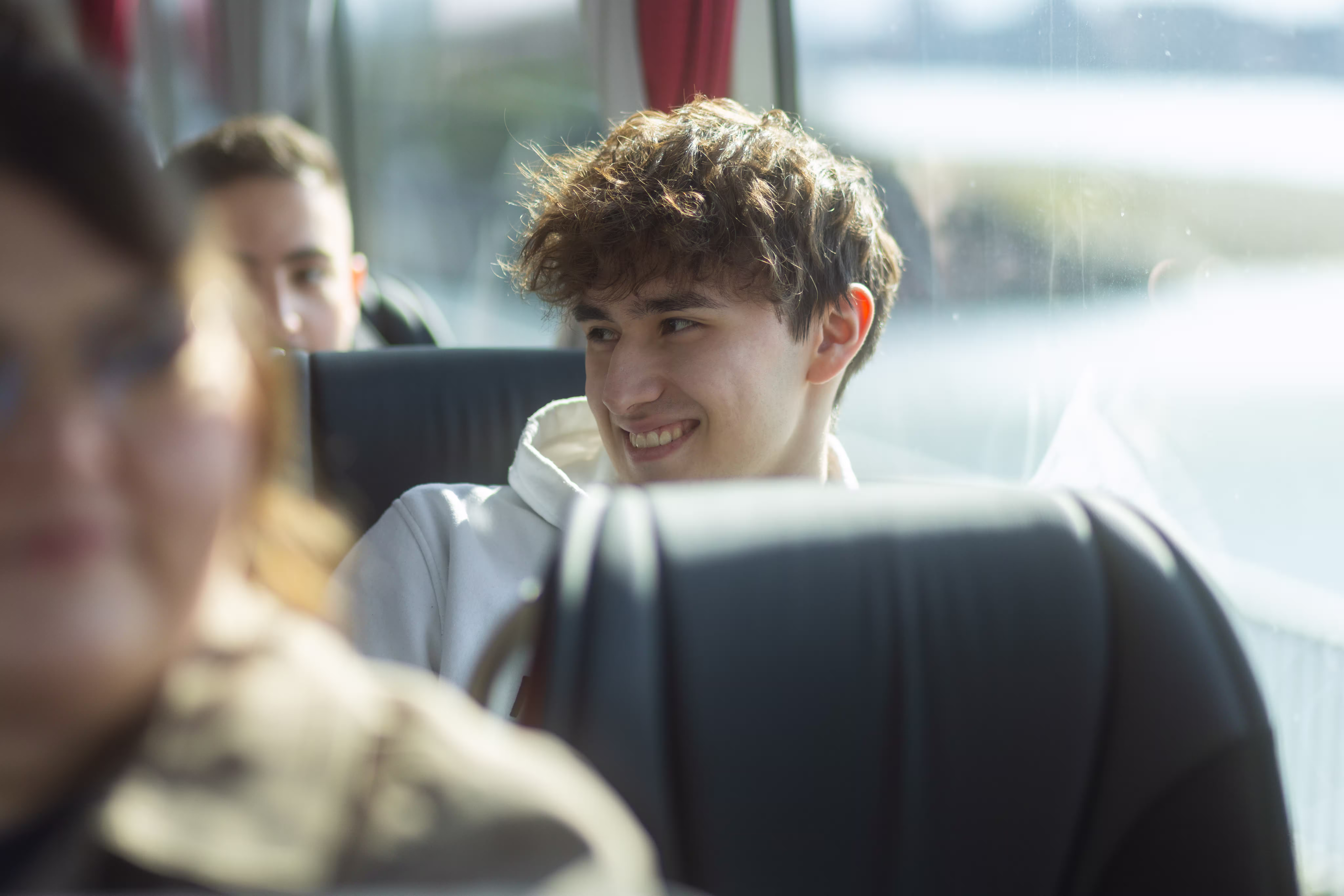 Lächelnder junger Fahrgast in einem Reisebus