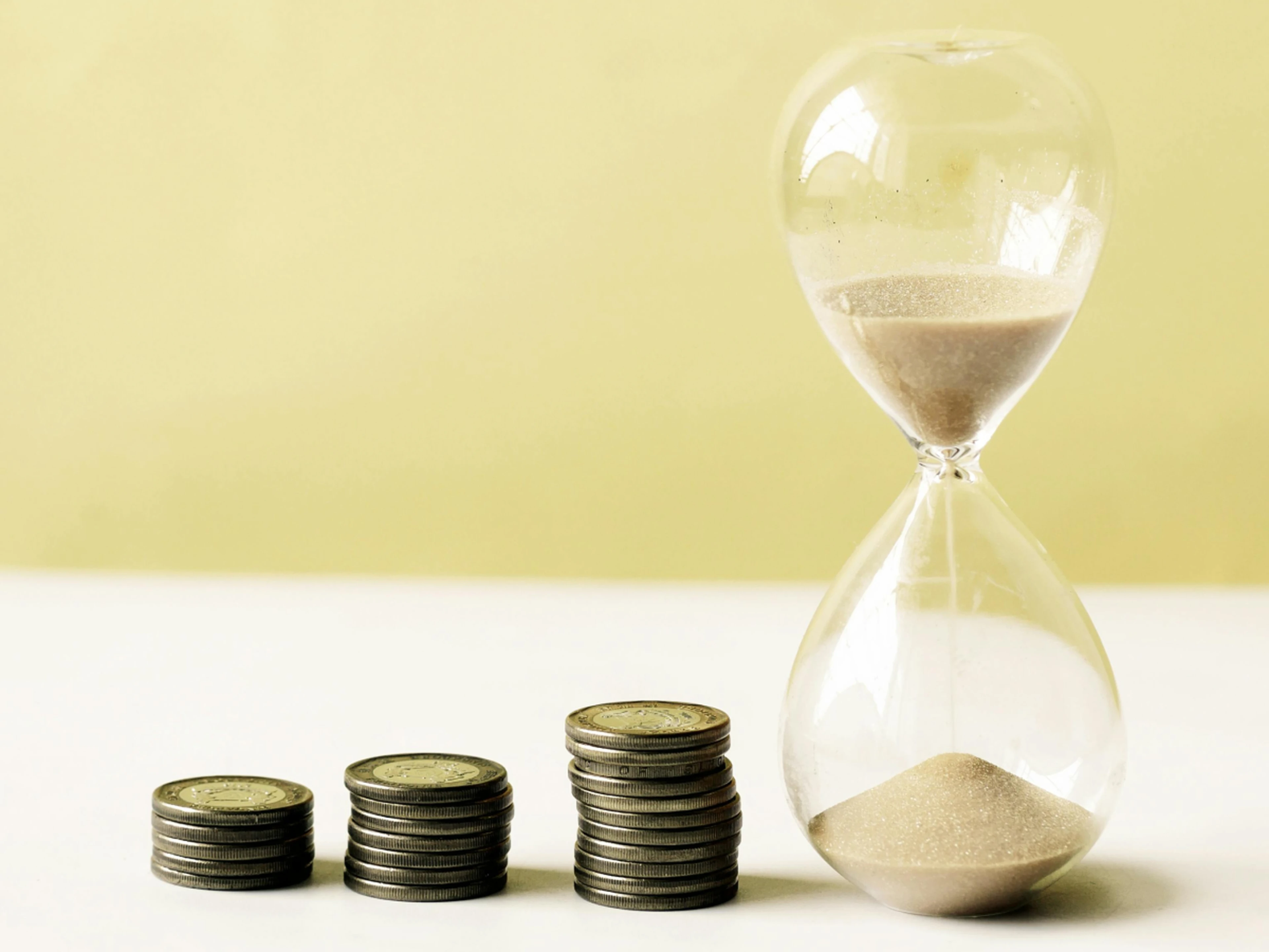 Stacks of coins next to an hourglass