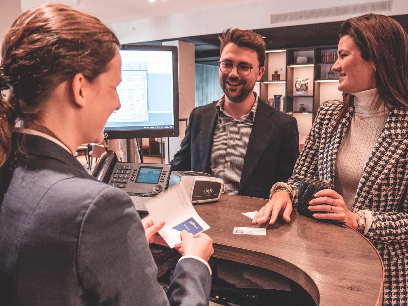 Hotelier checking guests in to a hotel at the front desk