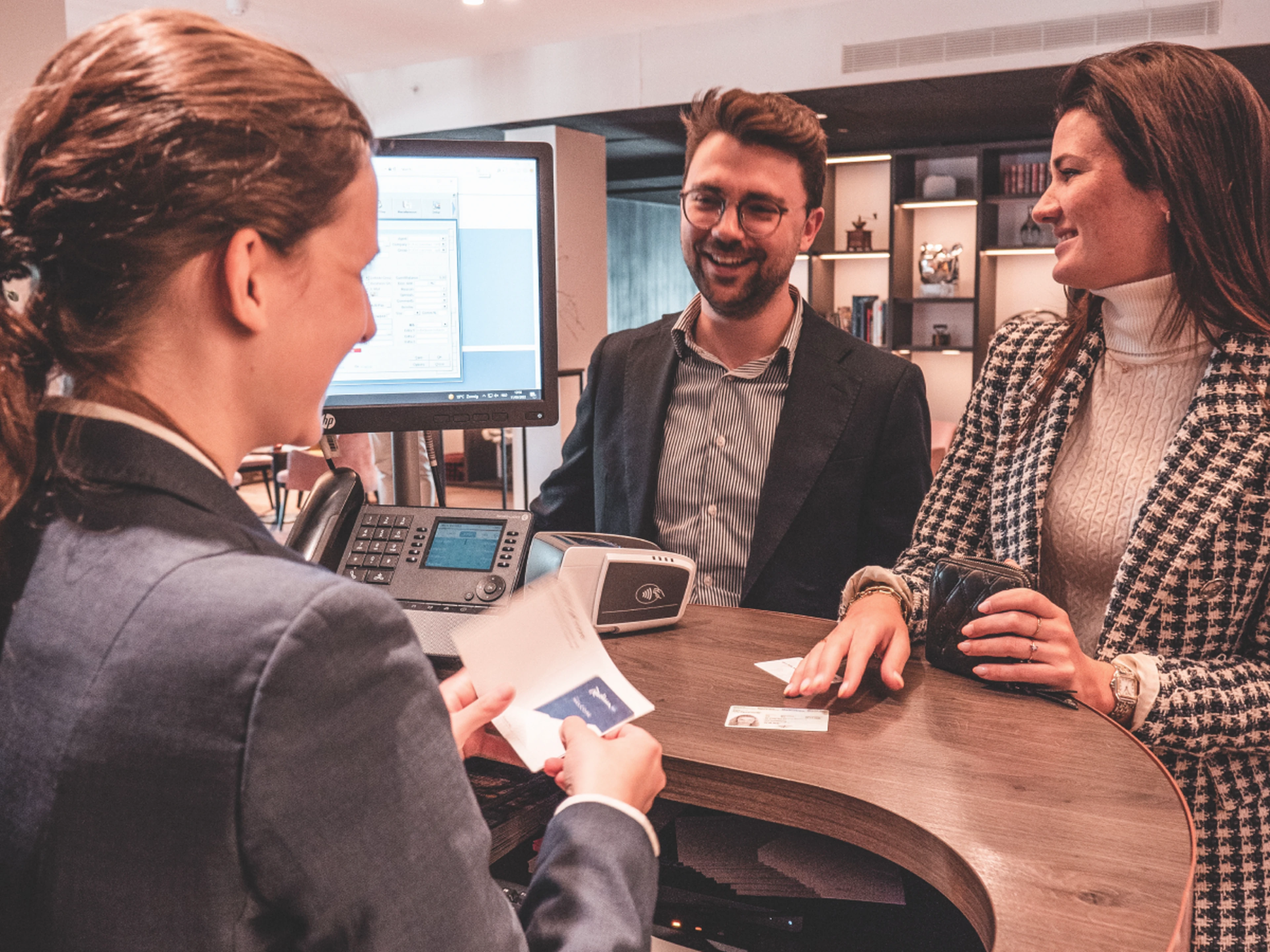 Hotelier checking guests in to a hotel at the front desk