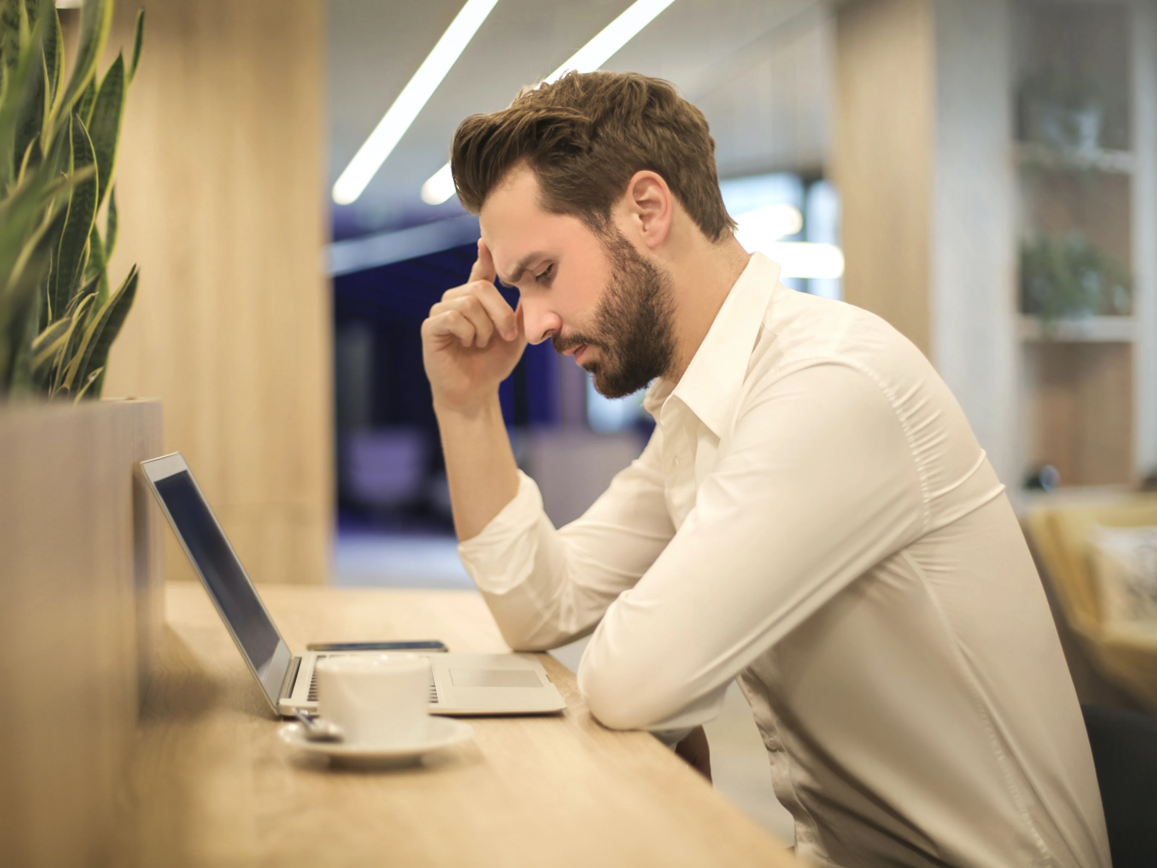 Man looks frustrated at laptop