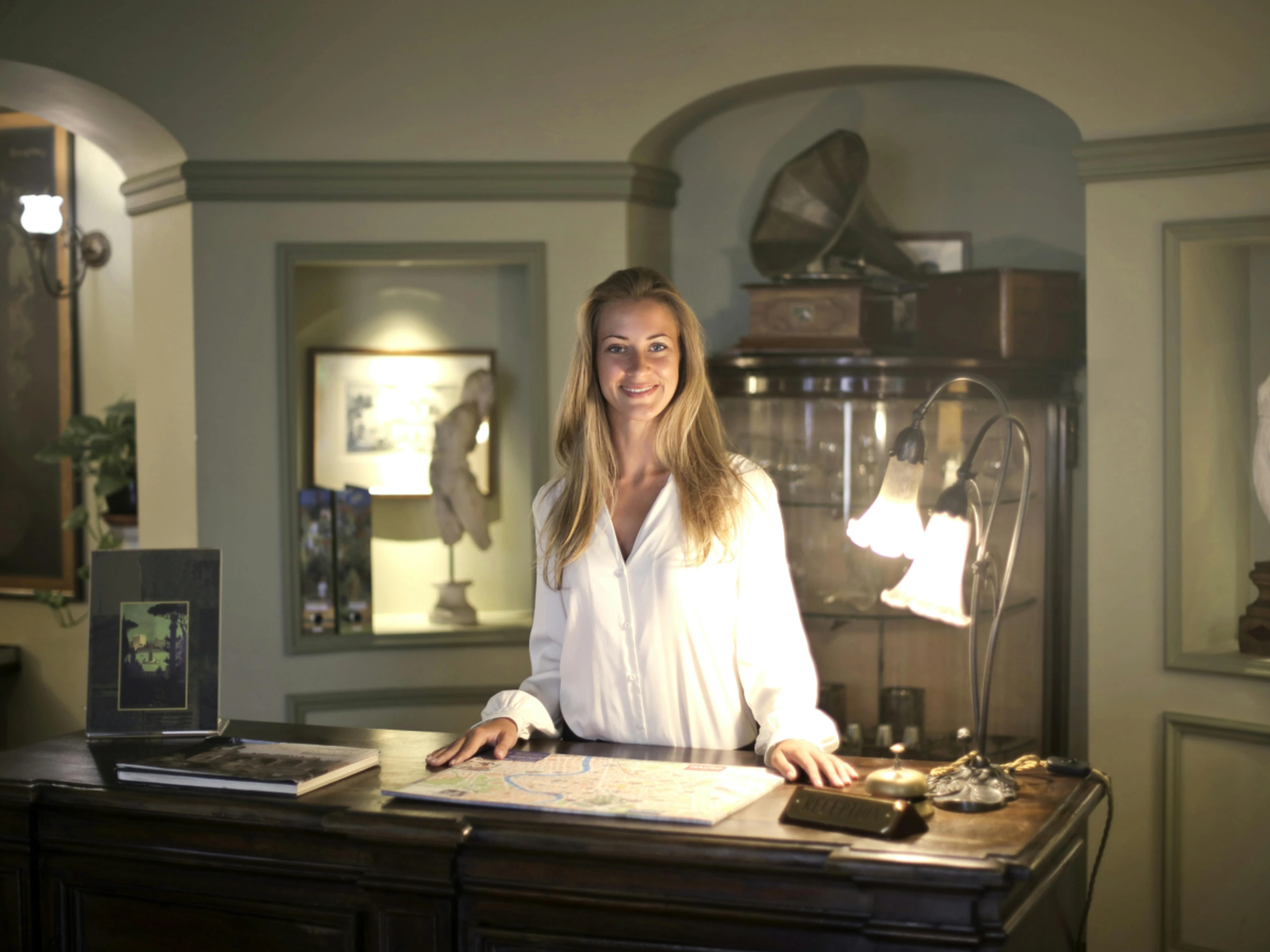 Hotelier standing behind the reception desk of a hotel