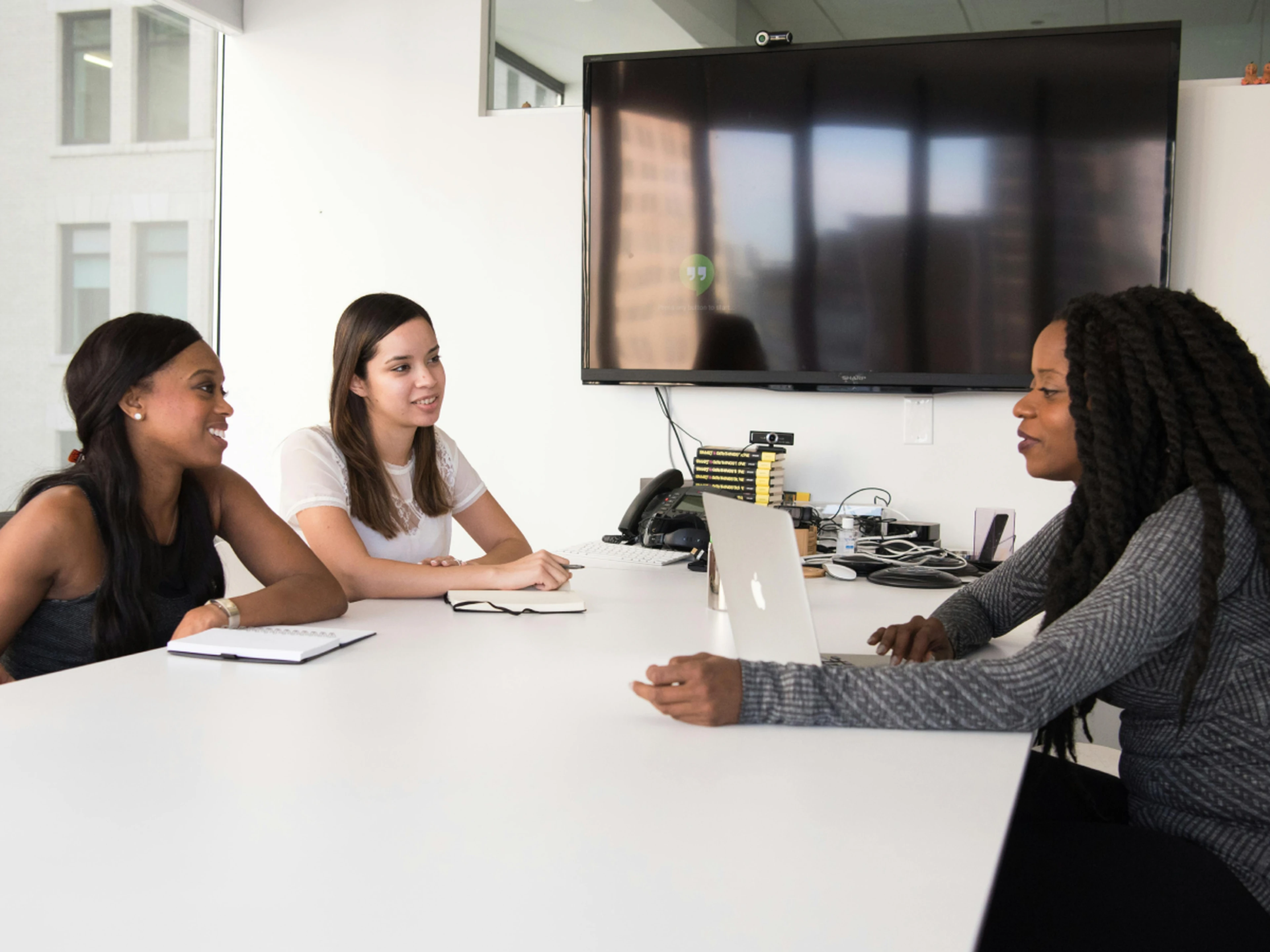 Three persons having a discussion during a meeting