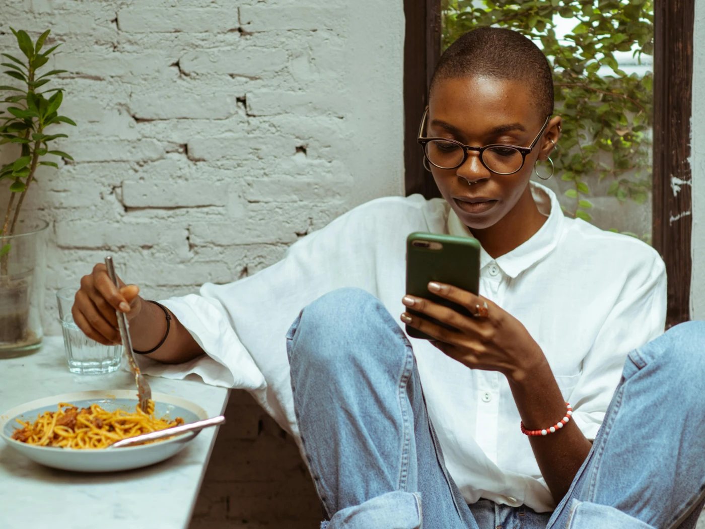 Woman looking at phone during dinner