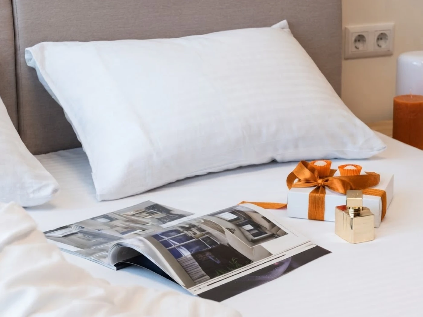 small present and magazine on top of a hotel bed