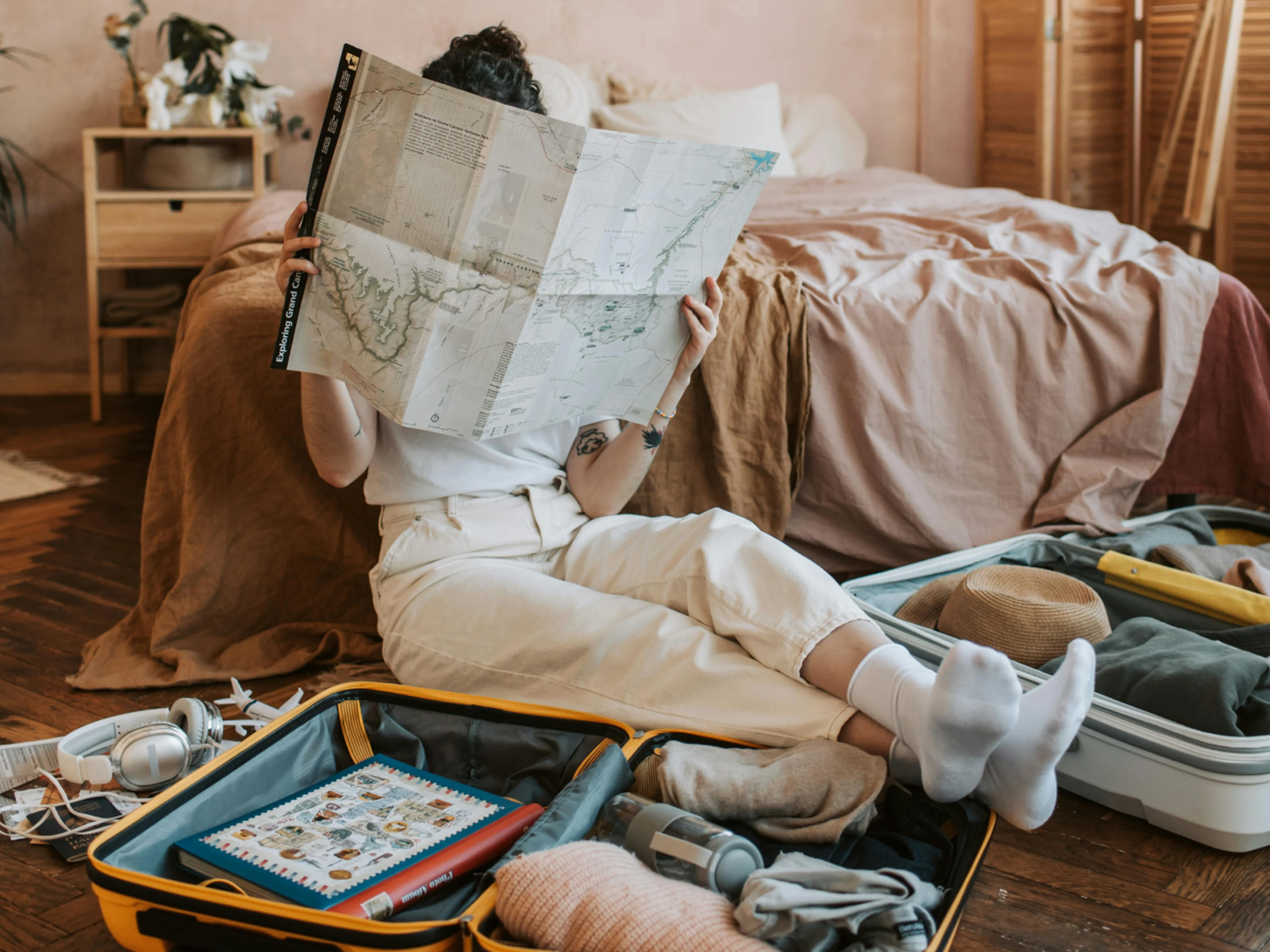 traveler packing suitcase holding a map