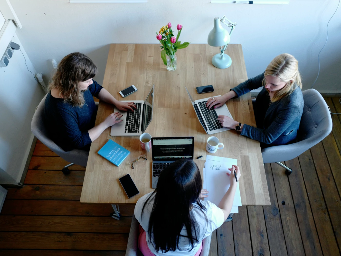team working together at a table on their laptops