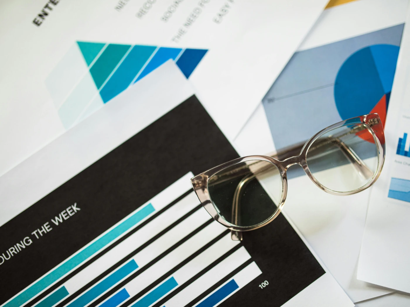 Glasses lying on top of various charts on paper