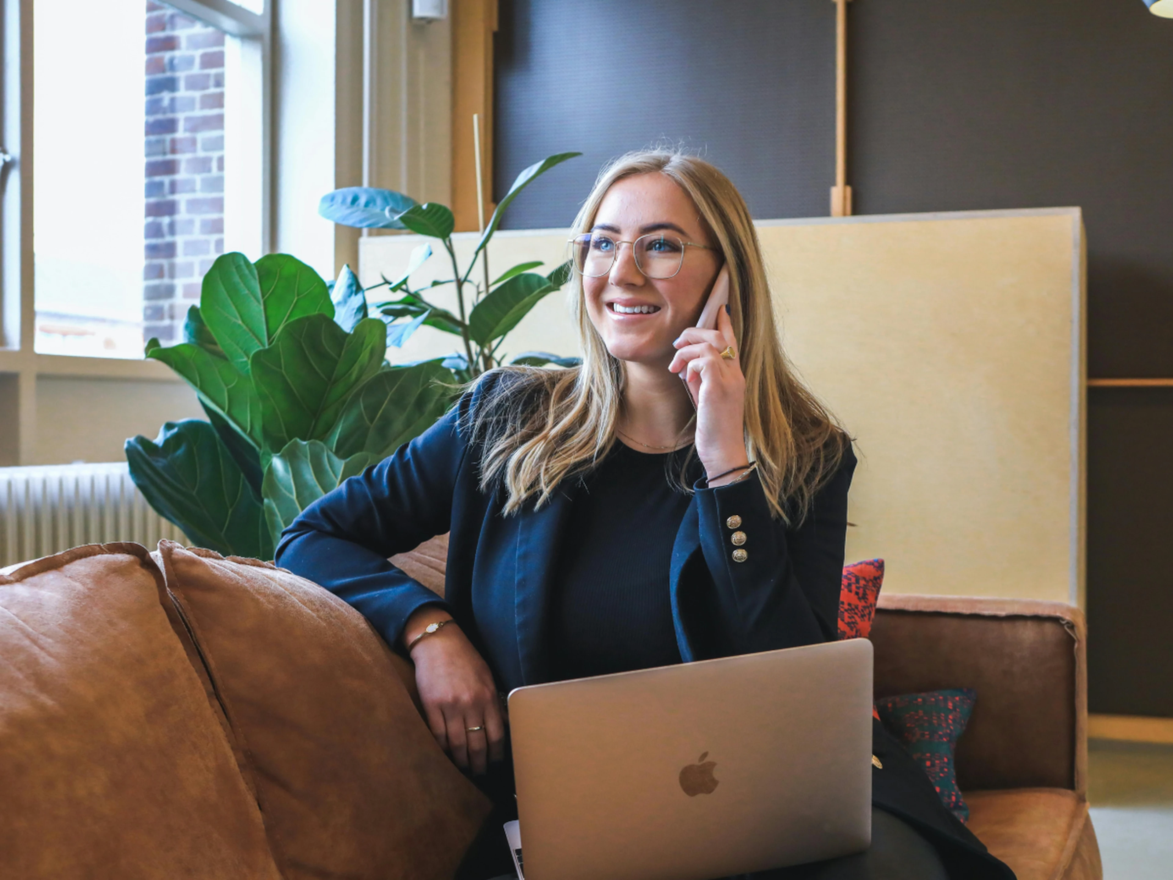 Hotelier working on her laptop and smiling while on the phone