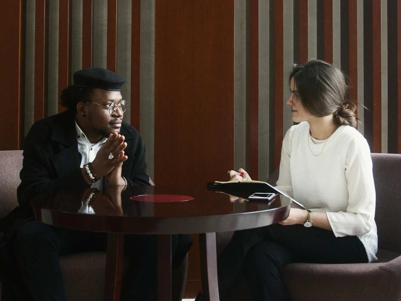 Two people in a hiring process, talking to each other and writing notes