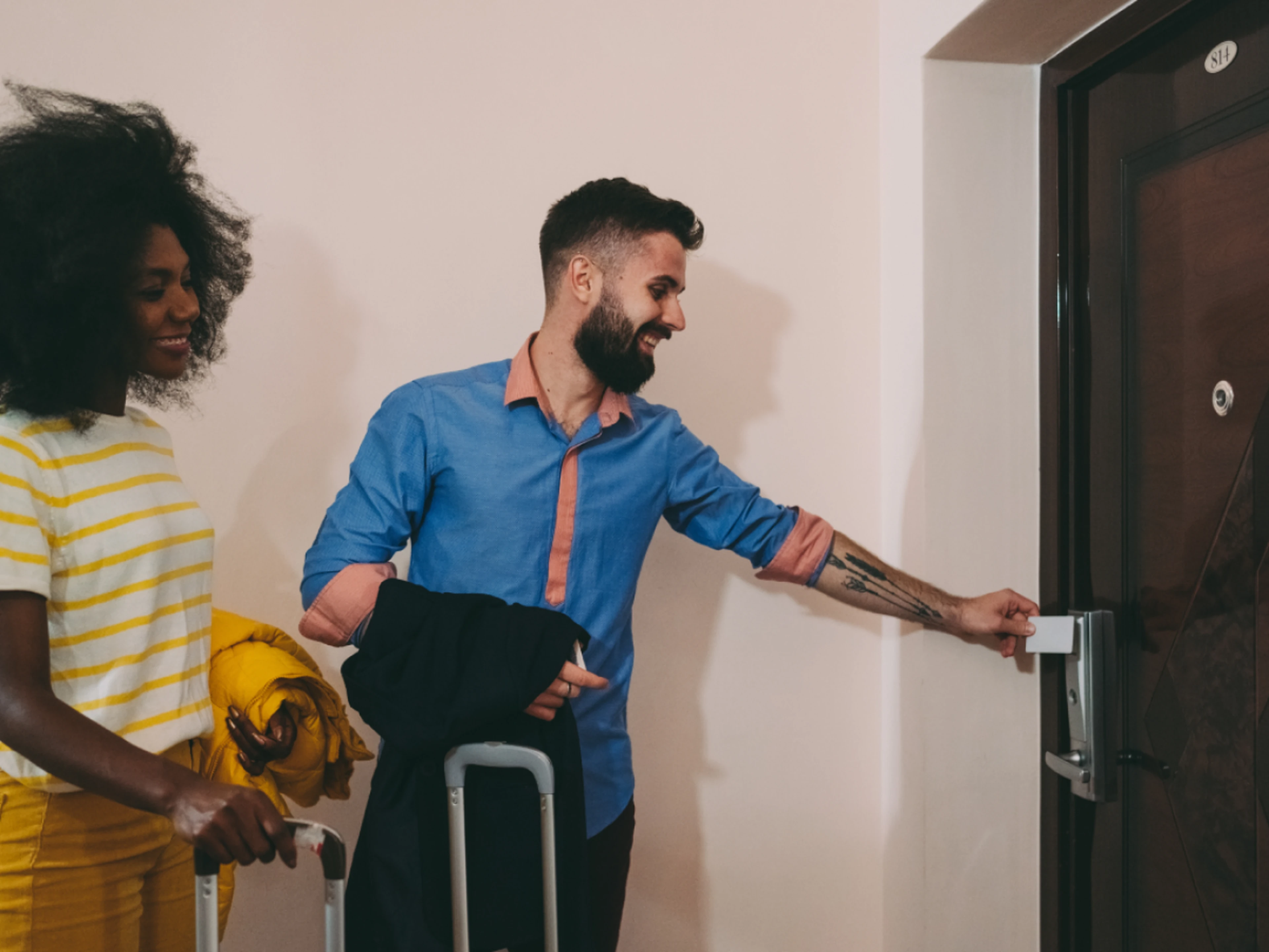 Guests with suitcases opening their hotel room door