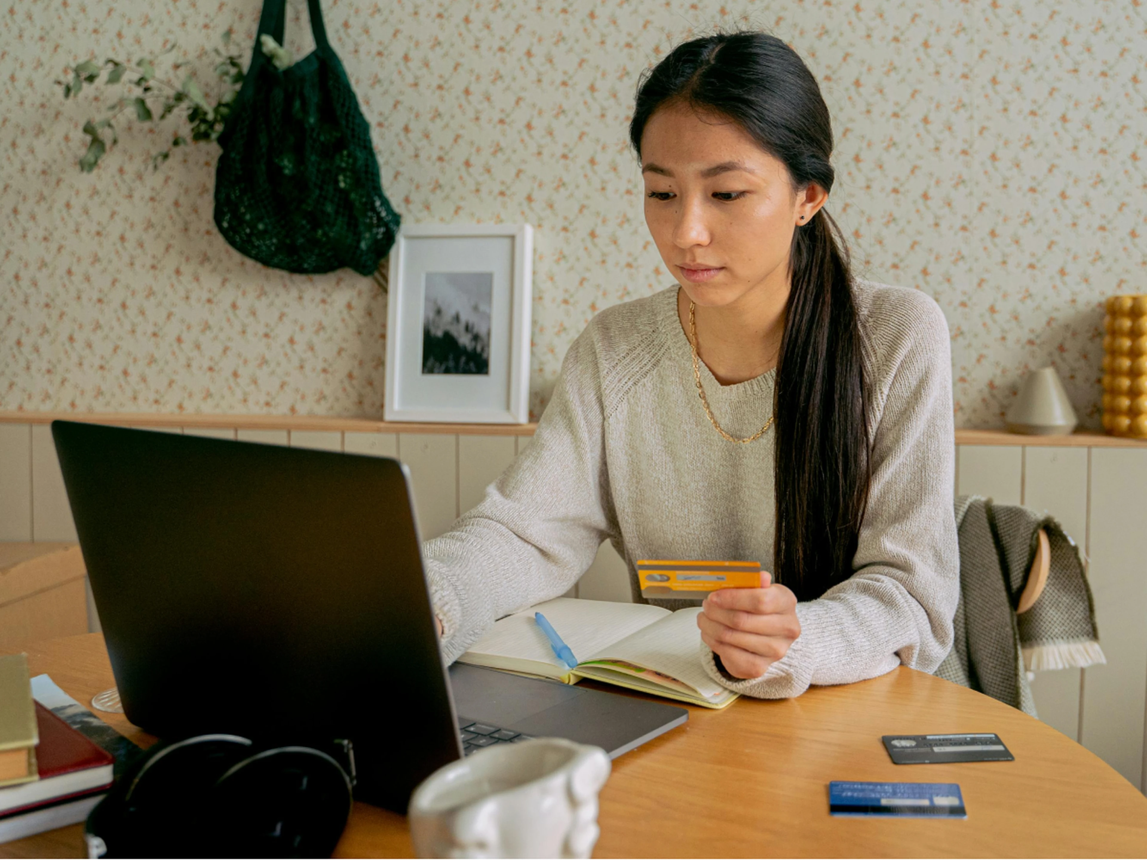 woman using a laptop and planning, with several credit cards at her disposal