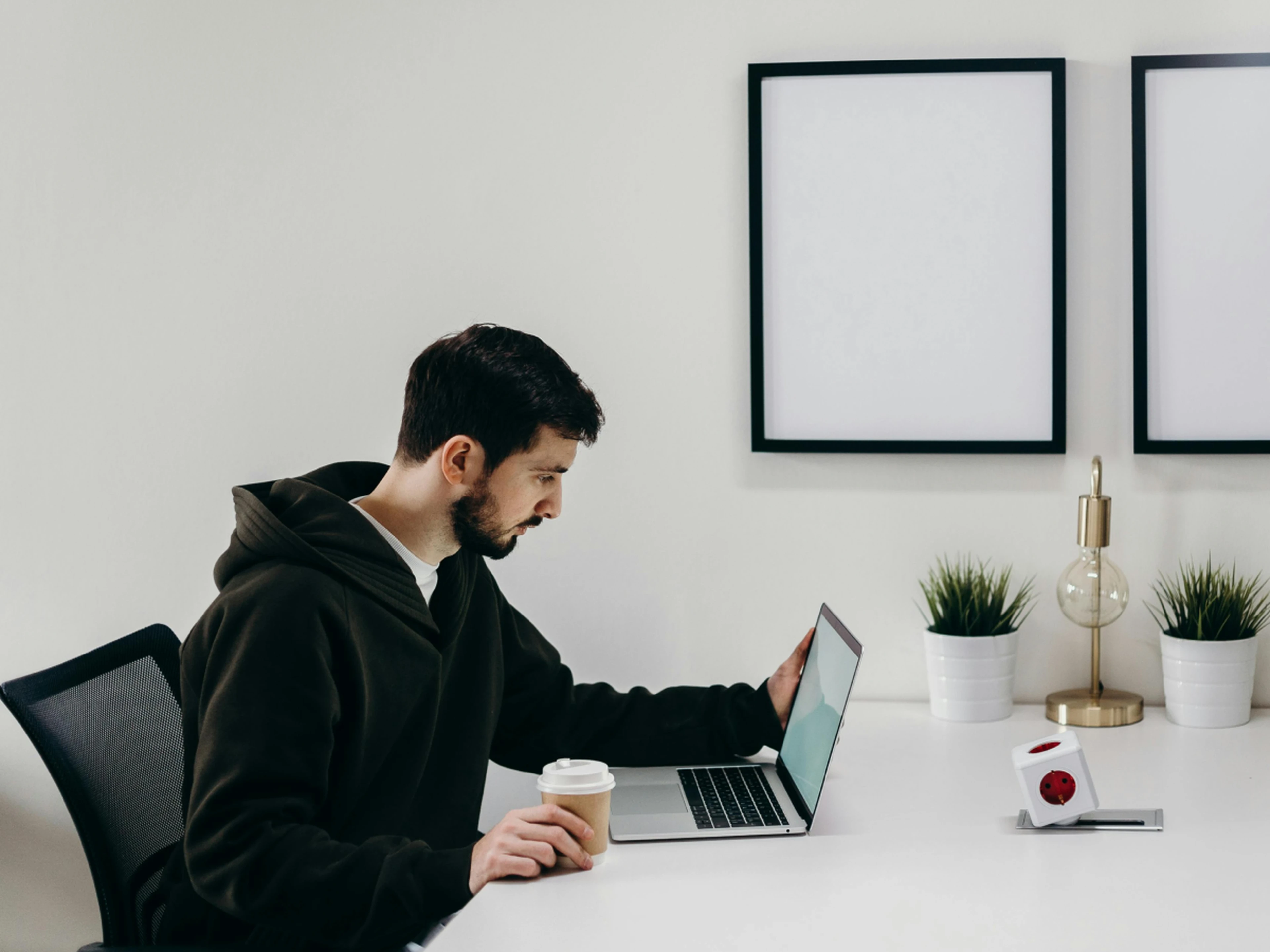 Man looking at laptop with a coffee