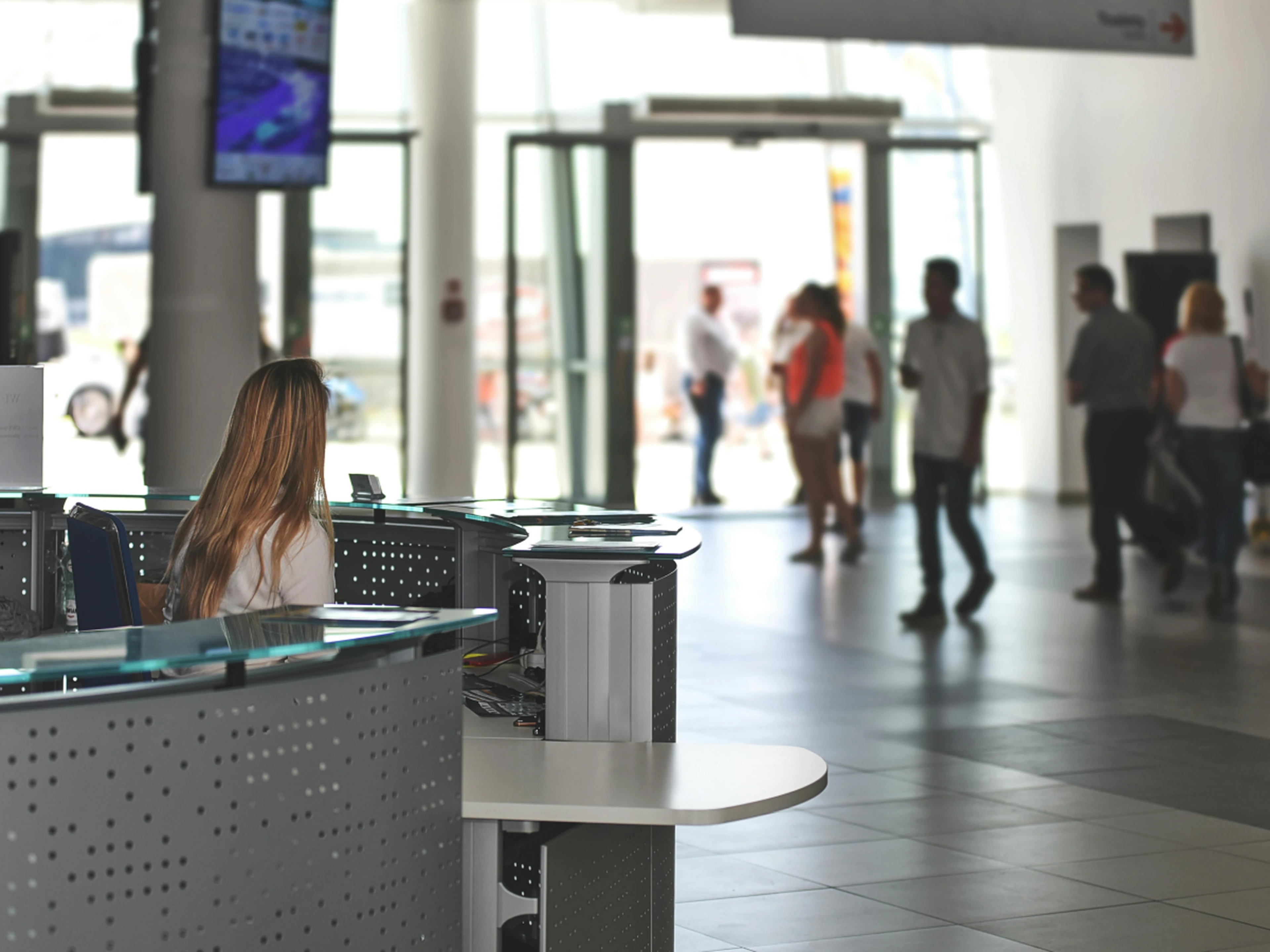 Hotel lobby with receptionist and people walking around