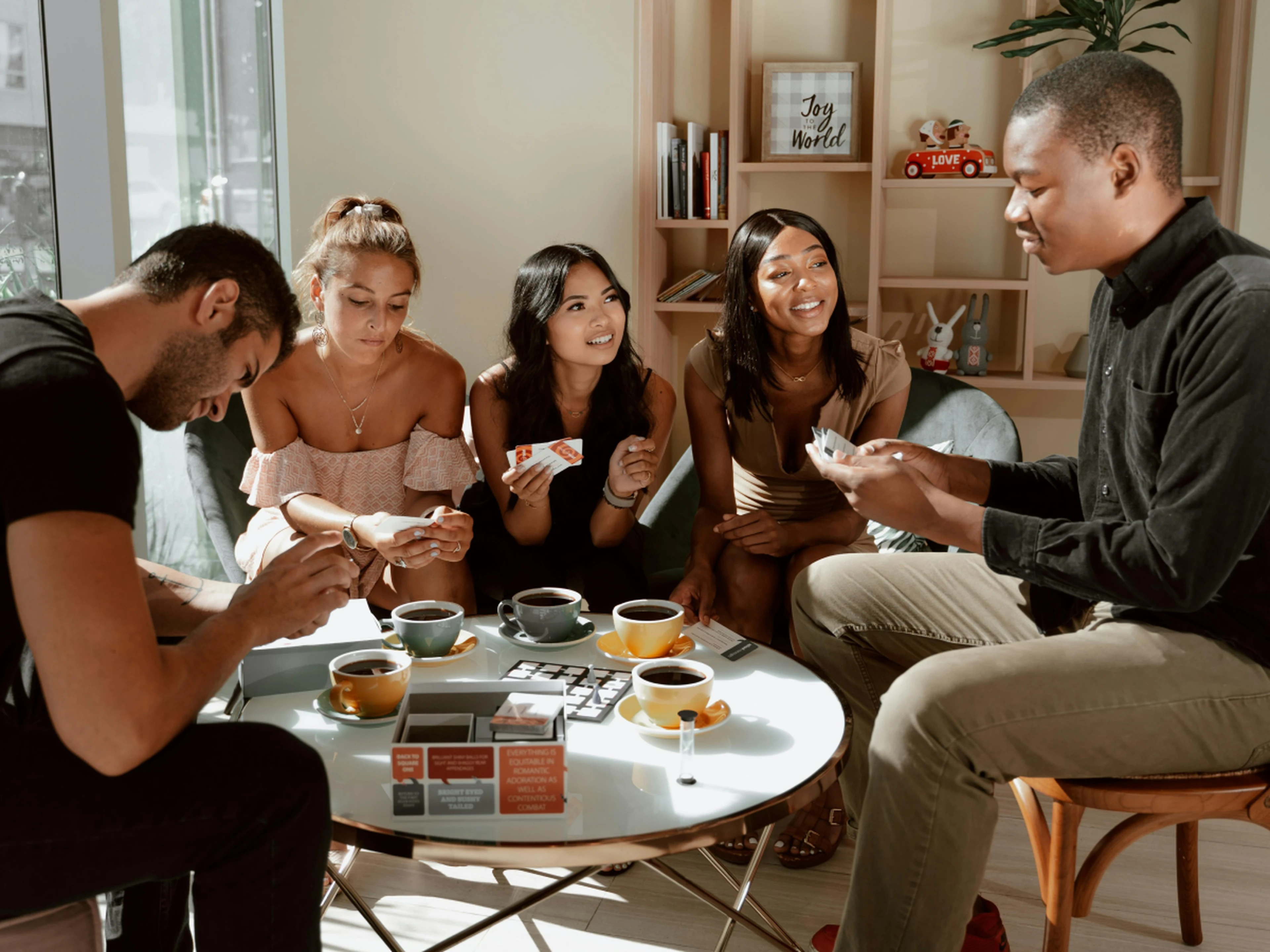 group of friends playing a board game and having coffee