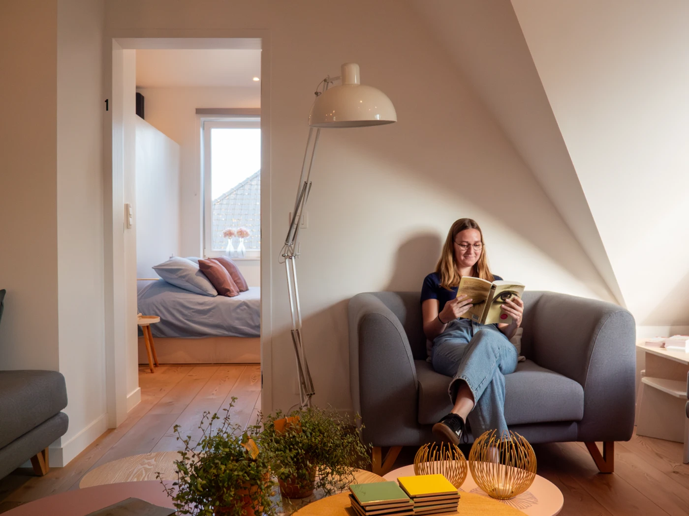 Person in a hotel room reading a book