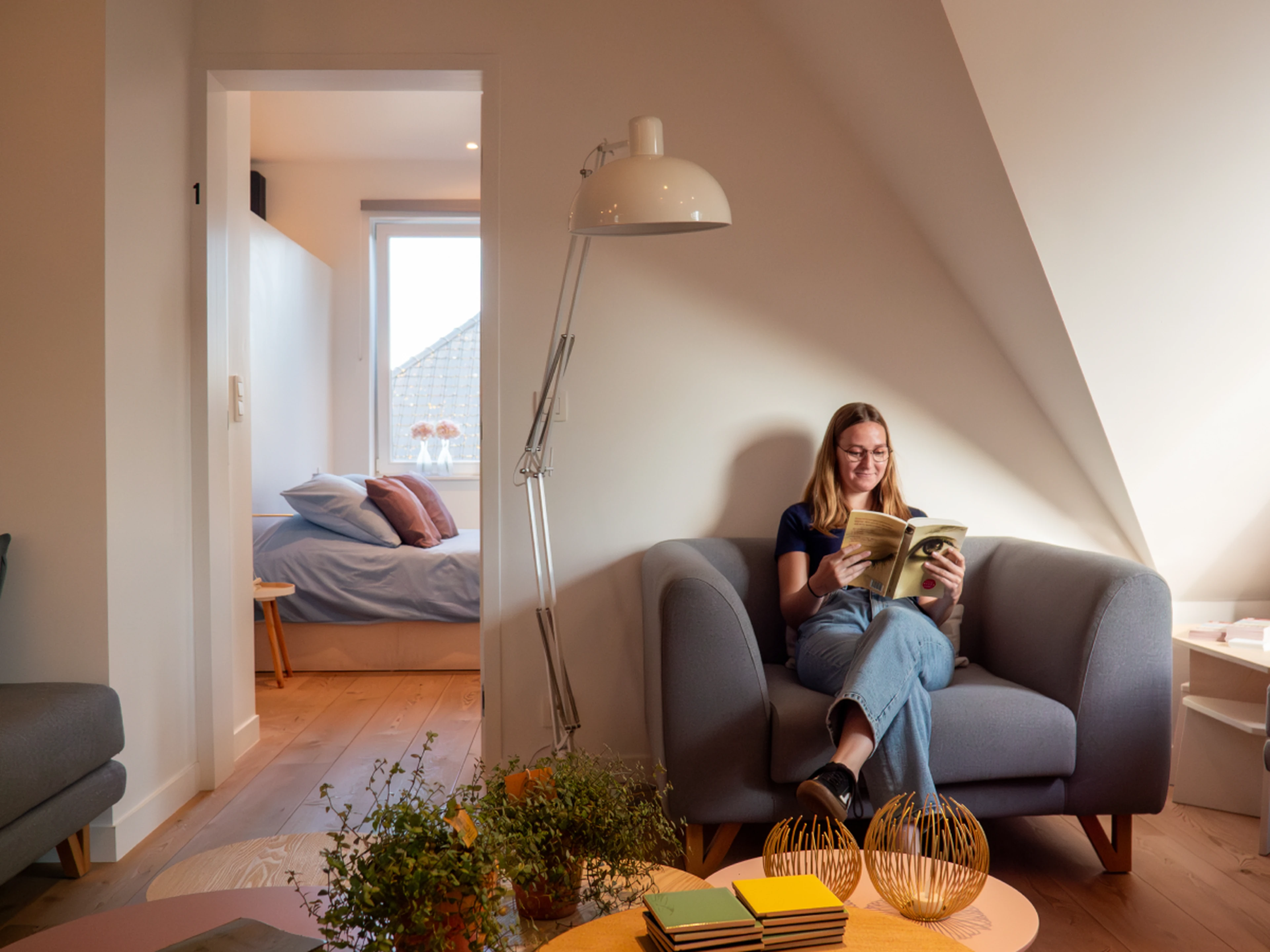 Person in a hotel room reading a book