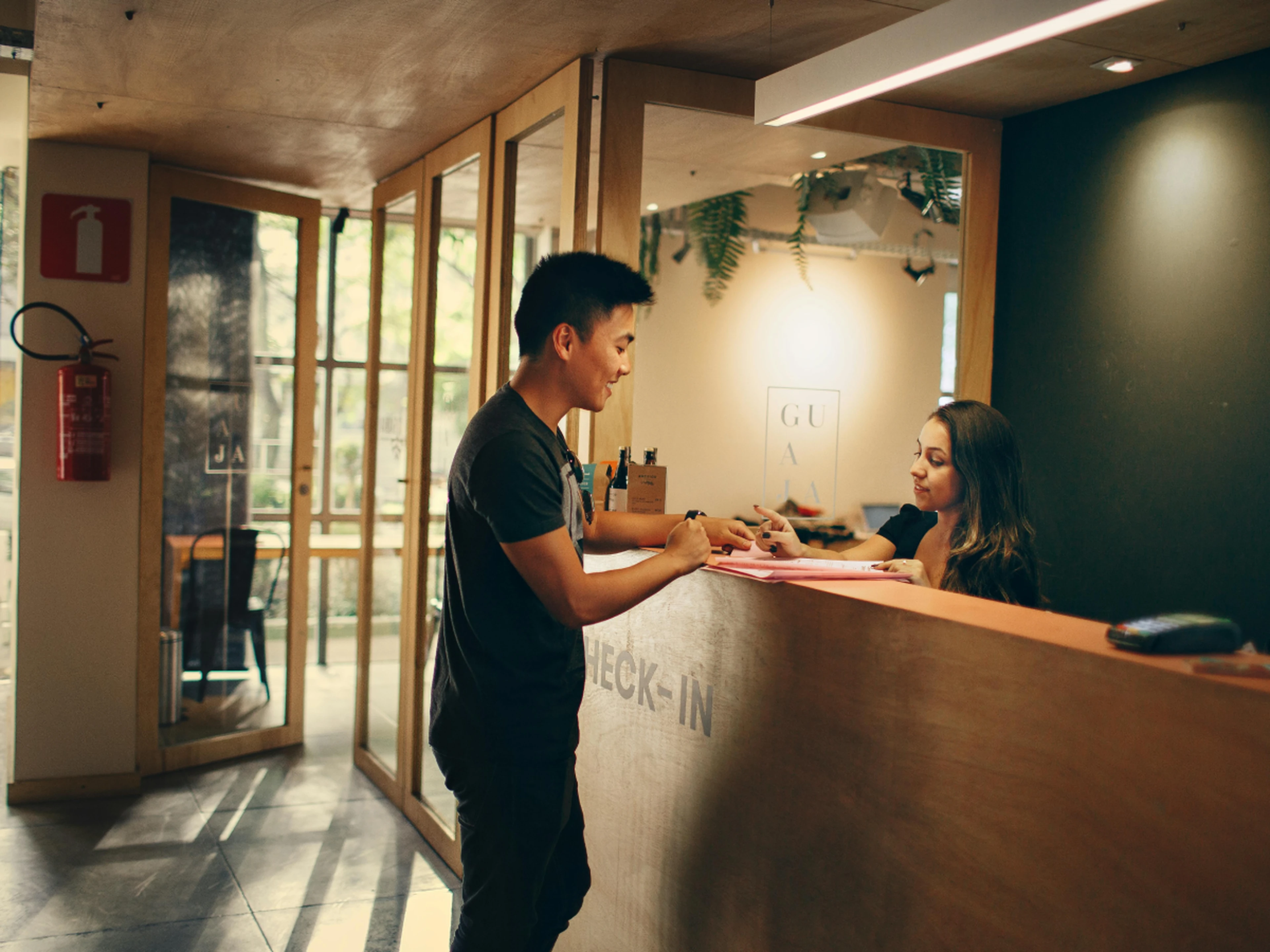Man at a reception desk being helped by a receptionist