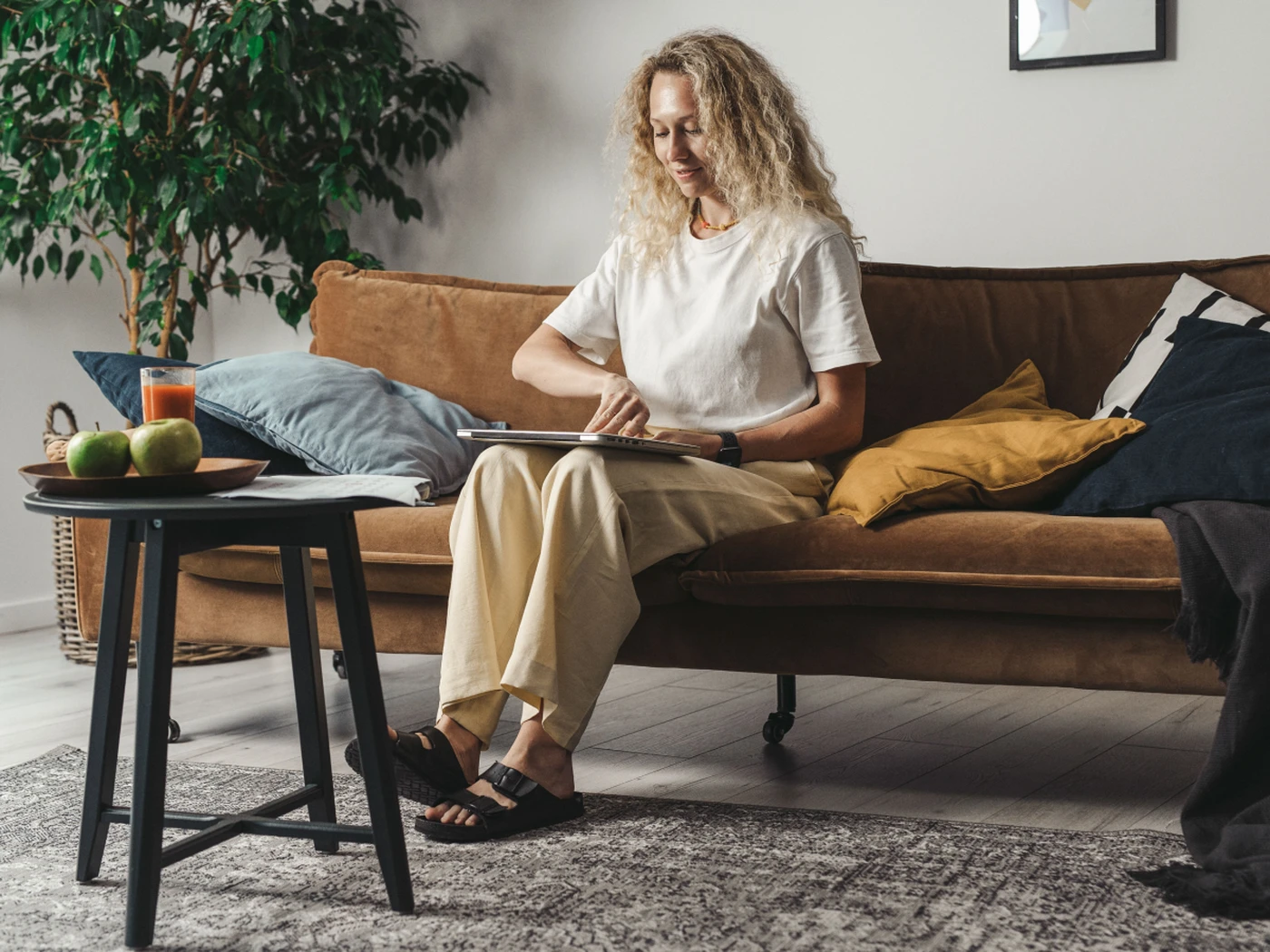 woman sitting on the couch about to open her laptop