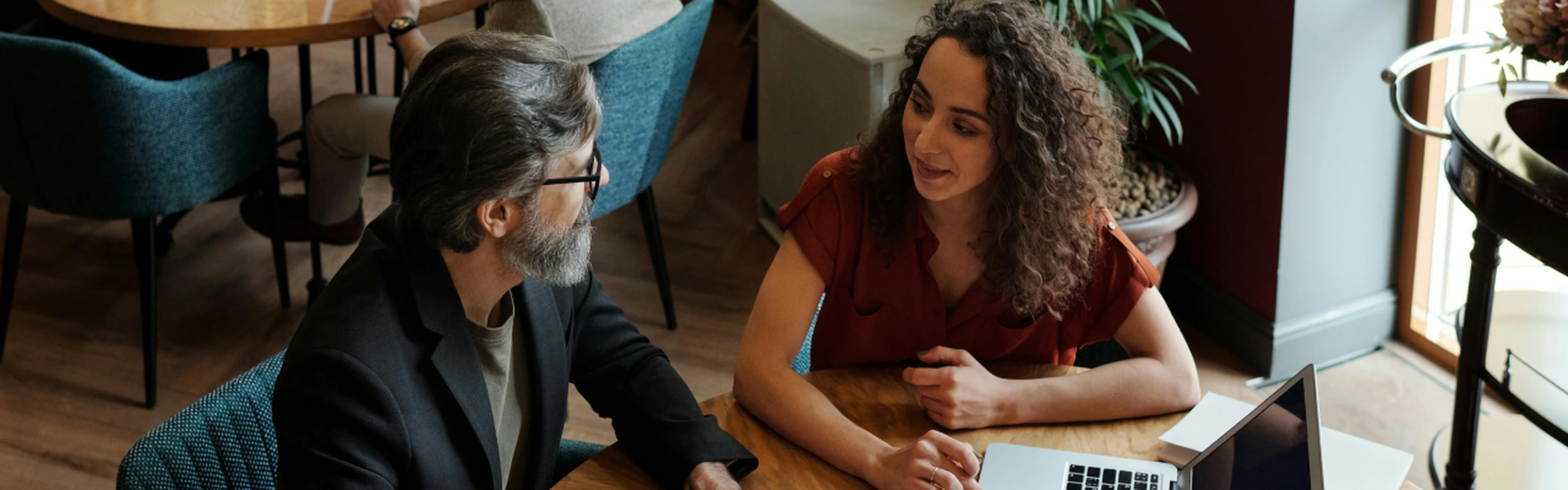 two people with a laptop having a meeting in a hotel restaurant