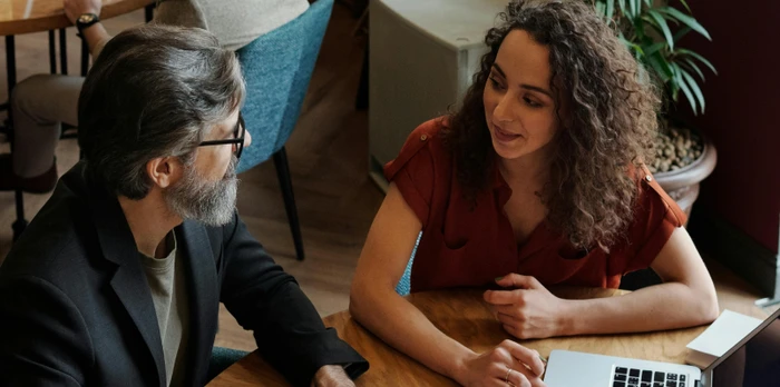 two people with a laptop having a meeting in a hotel restaurant