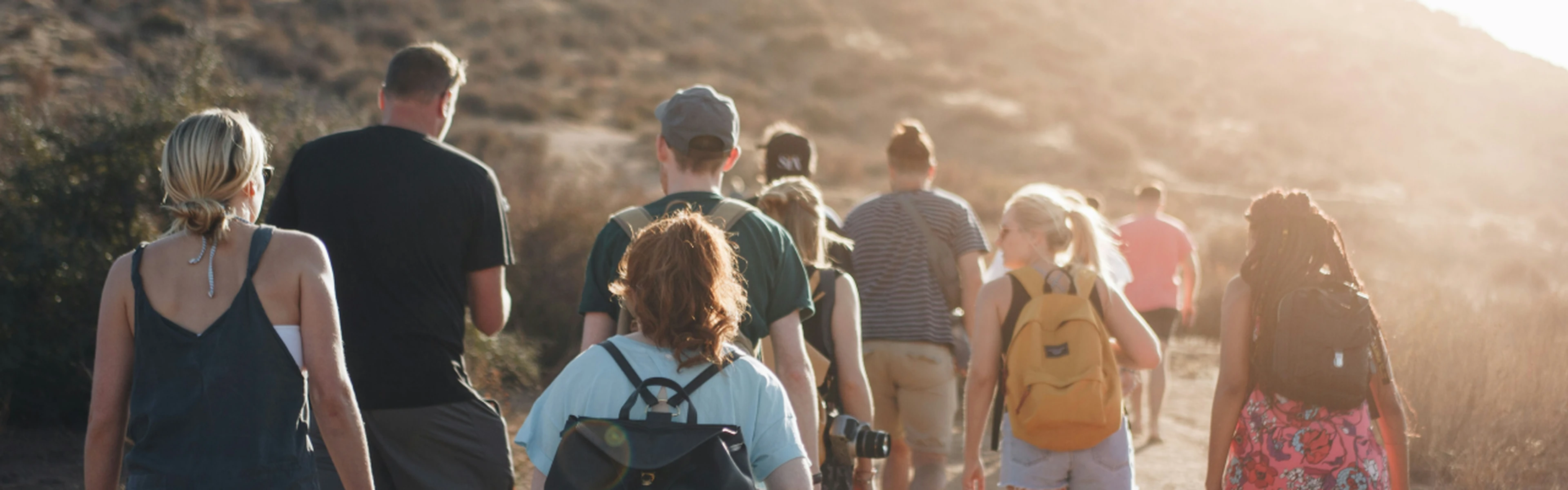 Group of people walking in a mountain area in the sun
