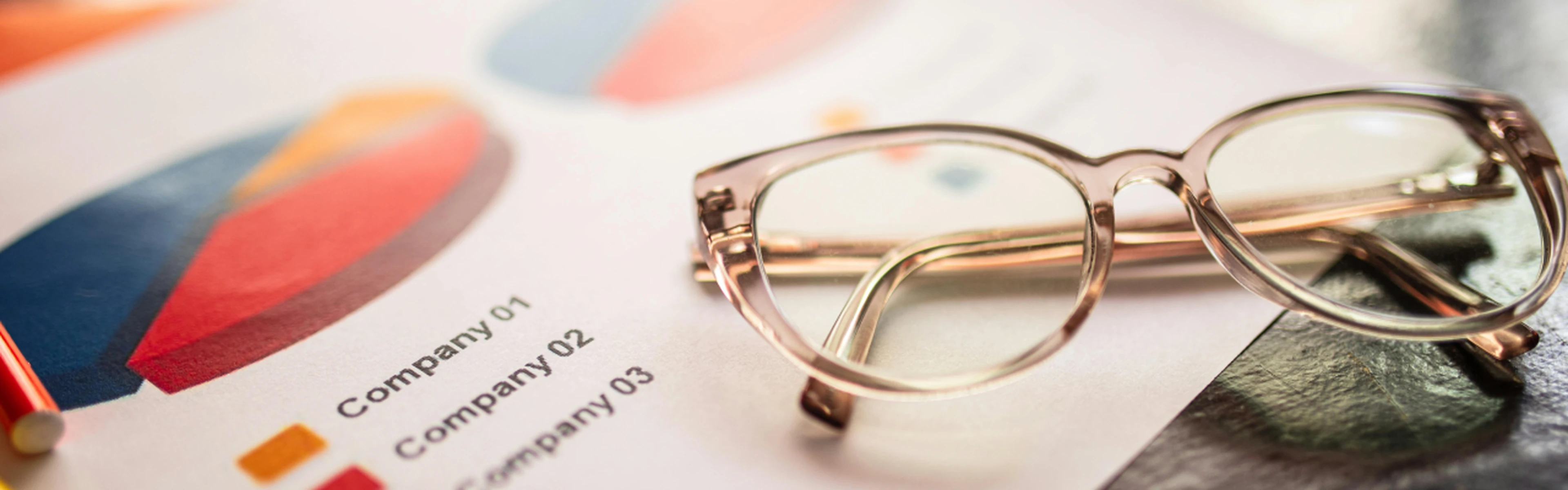 Lighthouse guide to hotel benchmarking: reading glasses resting on printed charts and graphs