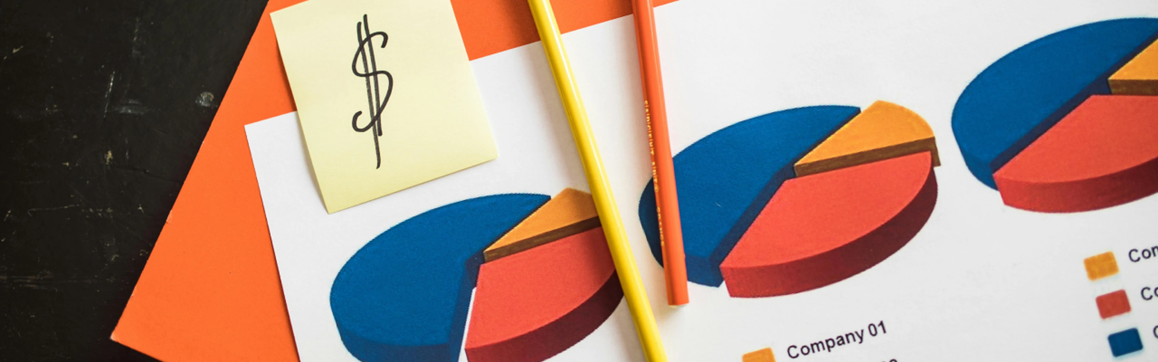 Paper with pie charts and a post-it note with a dollar sign on it