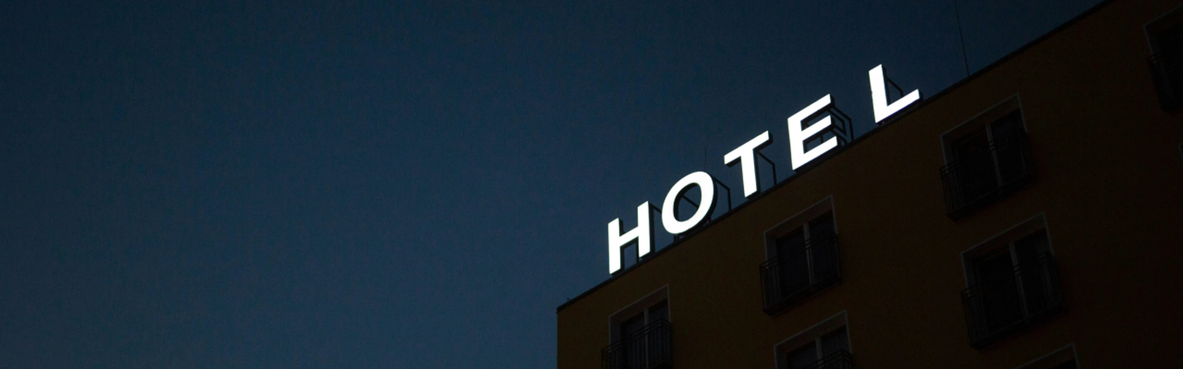 Hotel sign on top of a building during the night