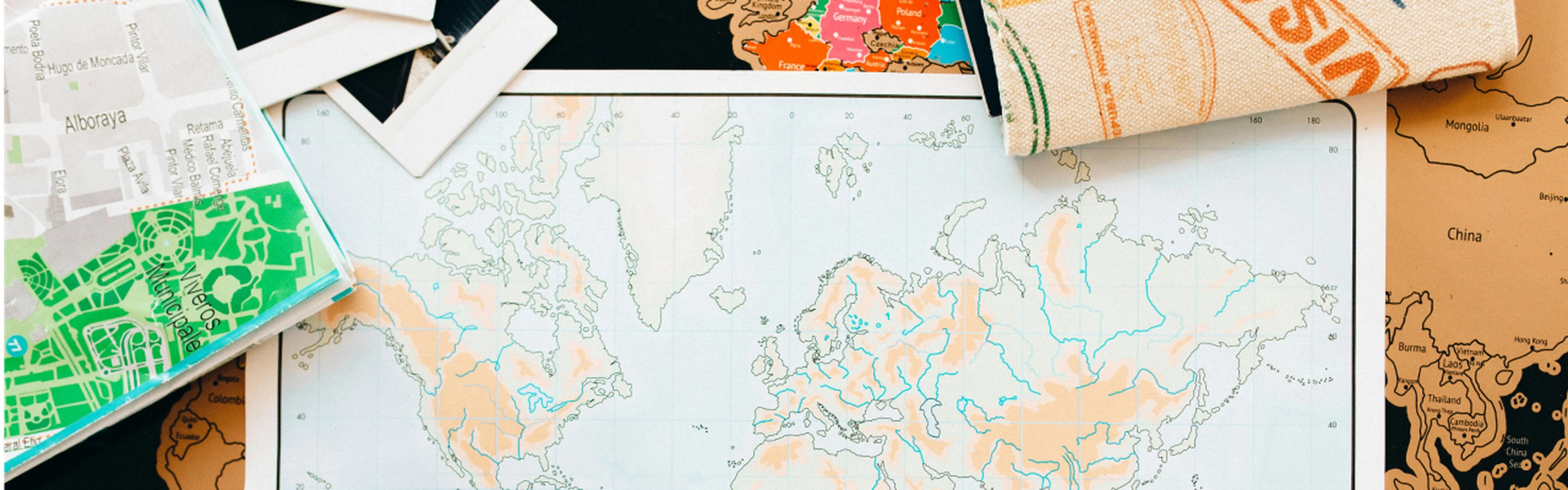 various world maps scattered across a surface