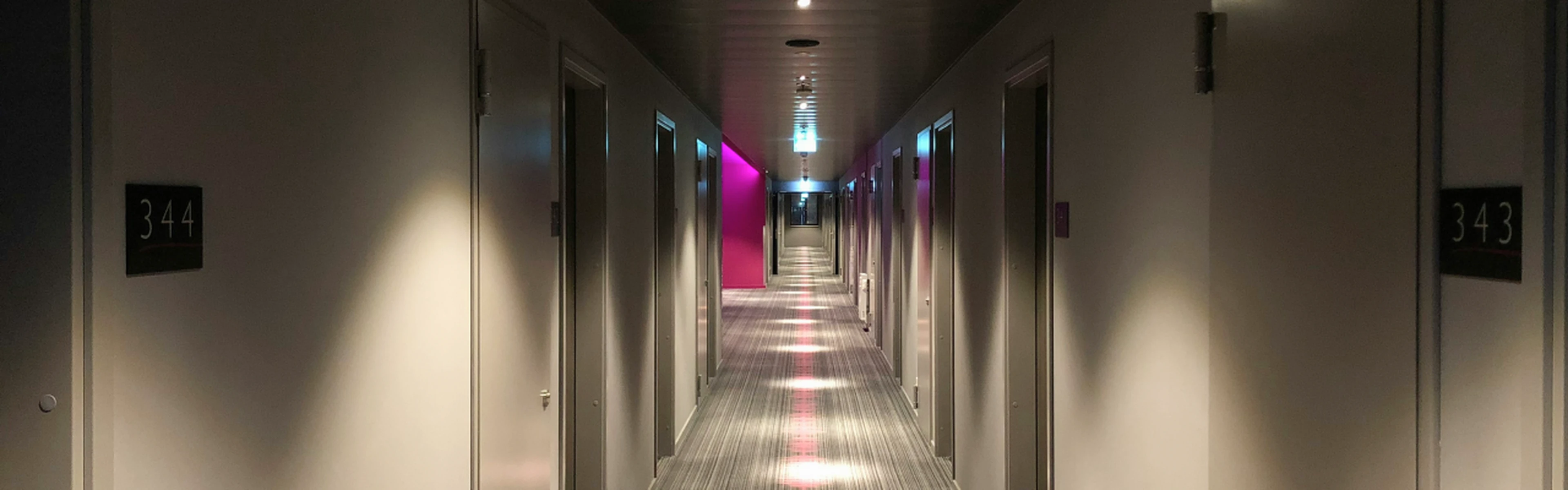 Hallway of a hotel with different doors to rooms