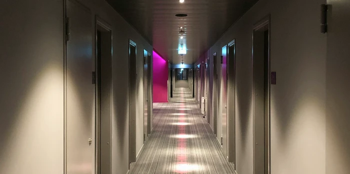 Hallway of a hotel with different doors to rooms