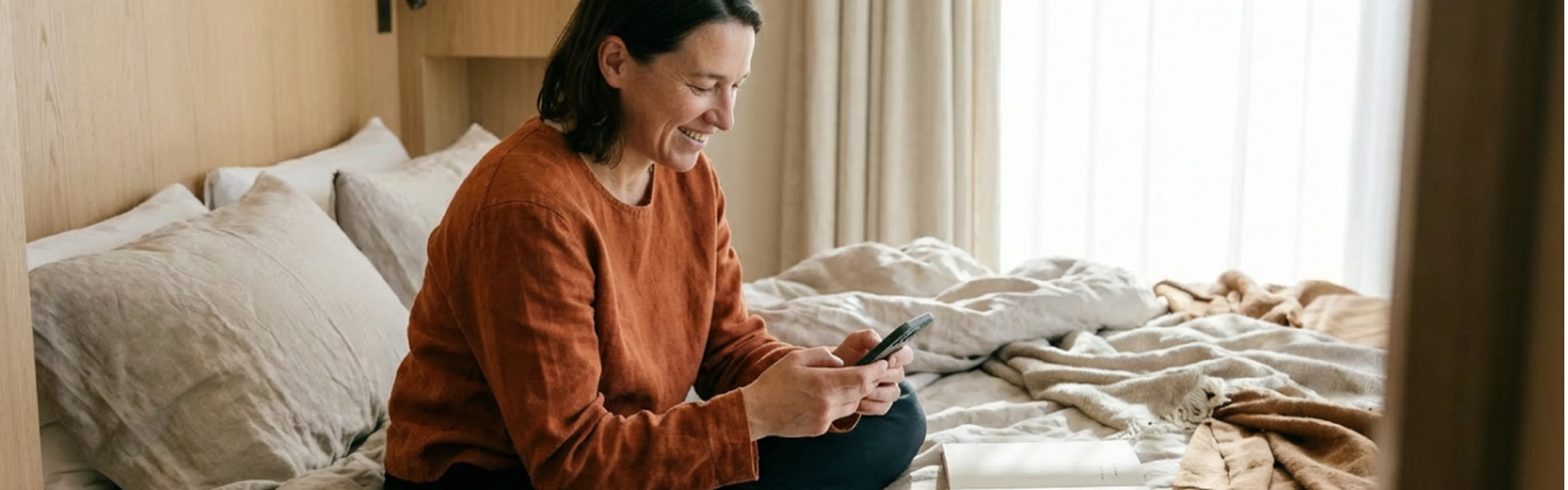 hotel guest in a hotel room reading an email on their smartphone