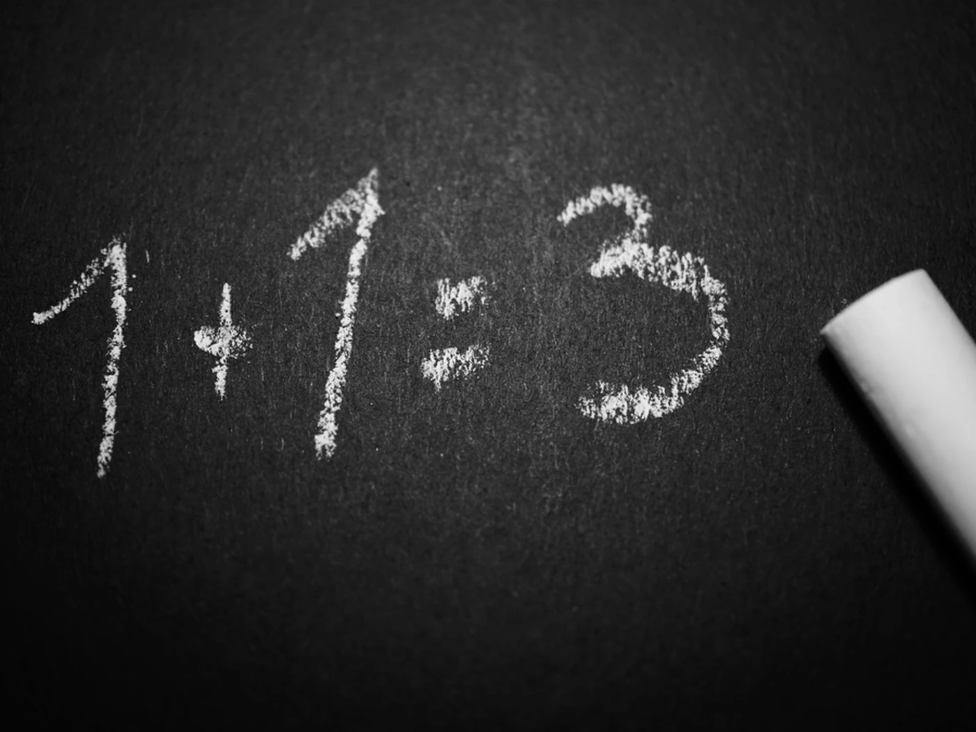 A chalk board showing 1+1=3 to symbolize manual errors in hotel revenue management