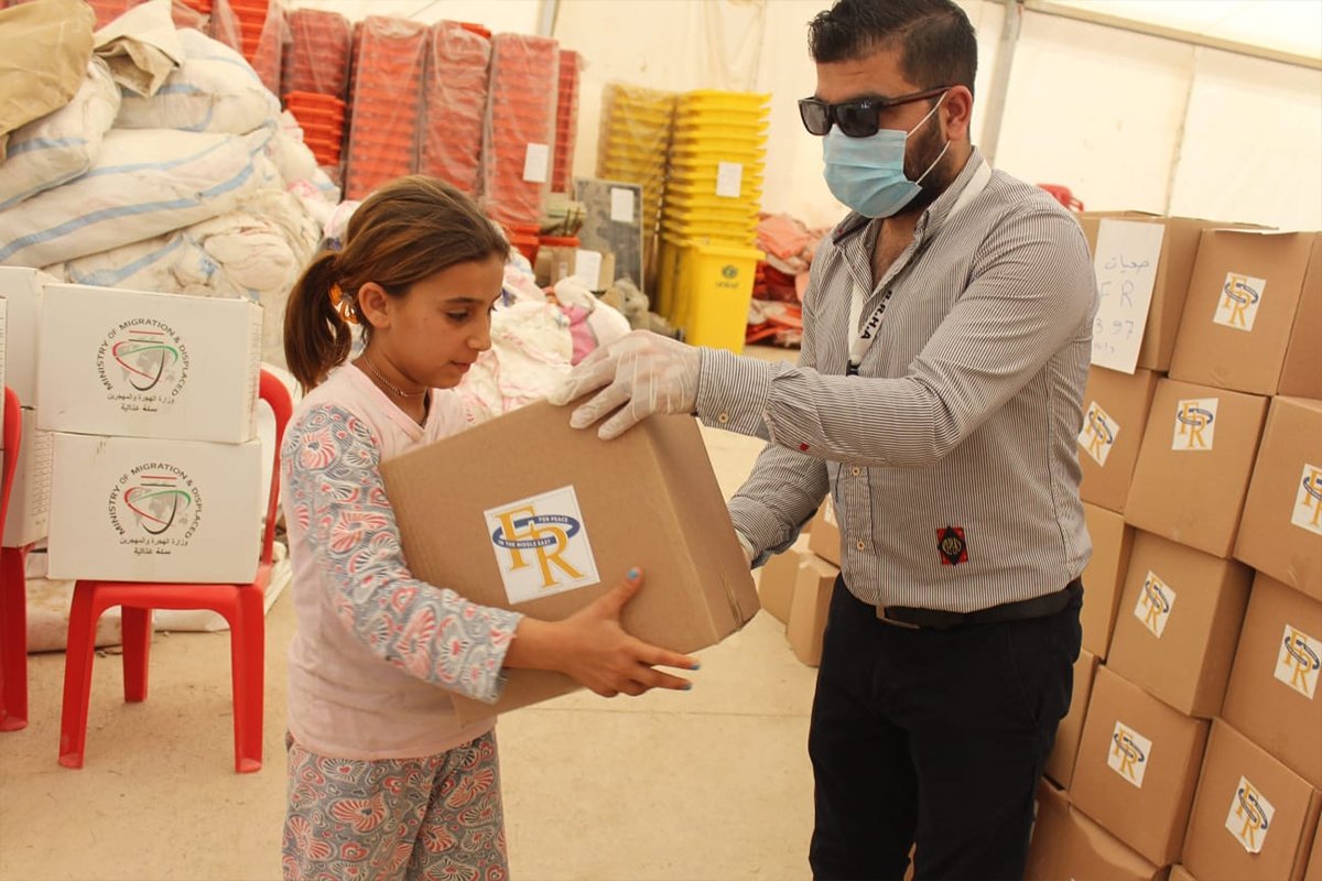 A young Yazidi girl receives a hygiene pack, May 2020