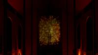 Dimly lit church interior with a glowing cross projection on the wall, surrounded by warm, abstract light patterns.
