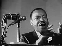 Image of Martin Luther King, Talking in several microphones. Black and white movie still.
