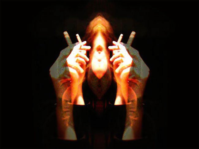 Abstract image of a person with mirrored hands holding cigarettes, creating a surreal, symmetrical effect against a dark background.