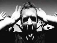 Black and white still image of three young men making a grimace with their hands waving beside their heads