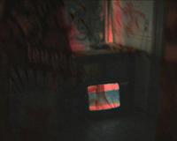A dimly lit room with a small TV displaying static colors. Red and dark shadows create an eerie atmosphere.