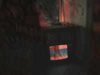 A dimly lit room with a small TV displaying static colors. Red and dark shadows create an eerie atmosphere.