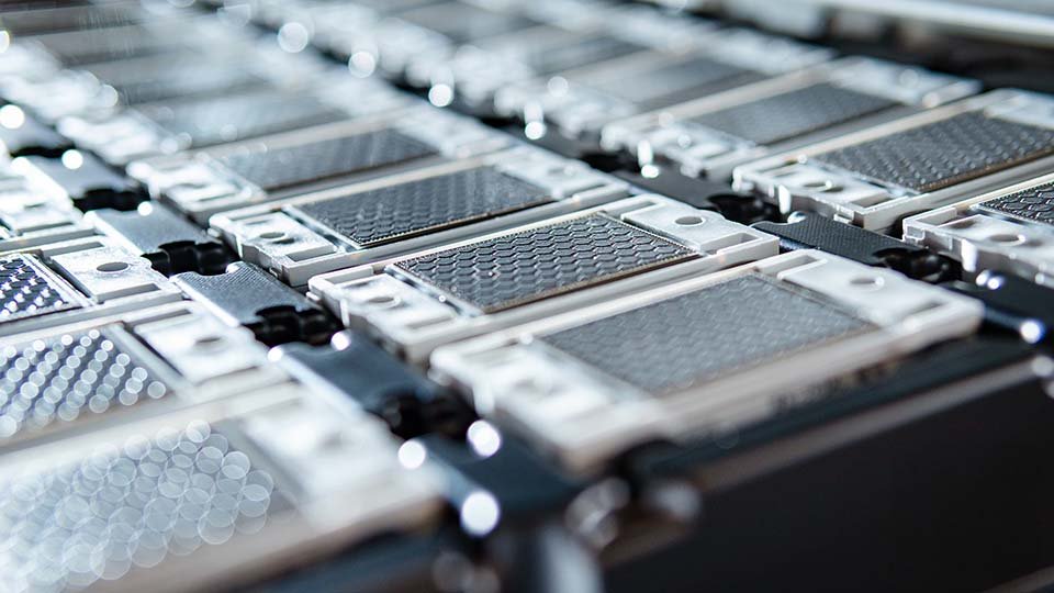 Close-up of a series of power modules arranged in a grid. The thermal interface material is visible.
