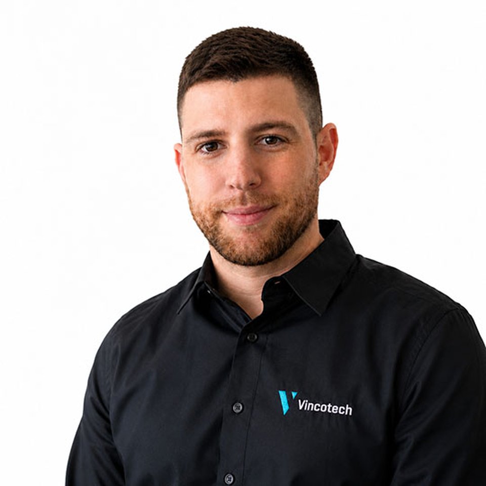 Gábor Nagy, wearing a black shirt, smiles while standing against a white background.