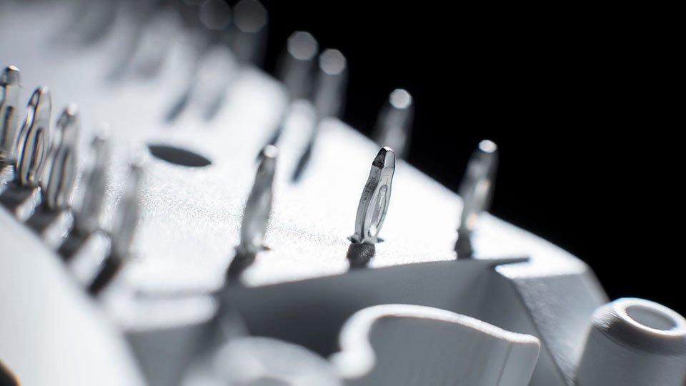 Close-up of a power module with multiple press-fit pins against a dark background.