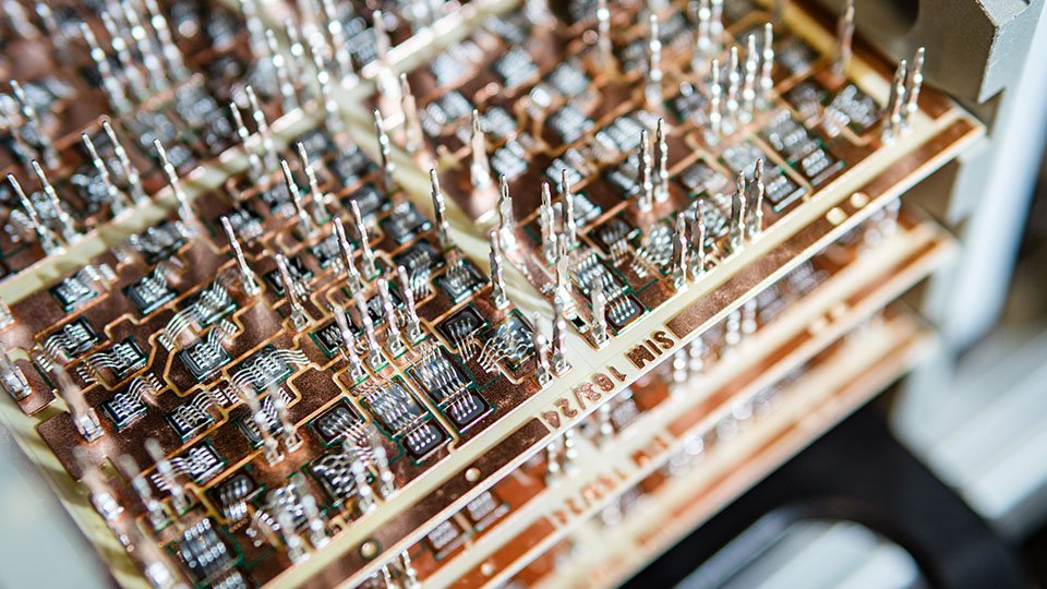 Close-up view of a circuit board with pins and components arranged in rows, showcasing intricate electronic details.